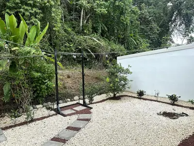 a garden with a fence and a white wall at Herradura casa vacacional in Herradura