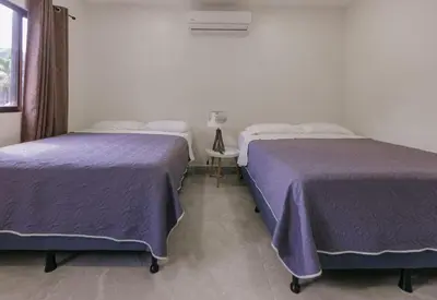two beds sitting next to each other in a room at Casa Sol in Punta Leona