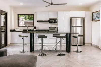 a kitchen with a large island with bar stools at Casa Sol in Punta Leona