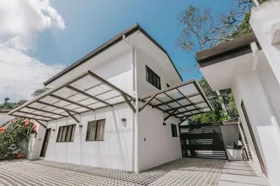 a white house with awning on a driveway at Casa Sol in Punta Leona