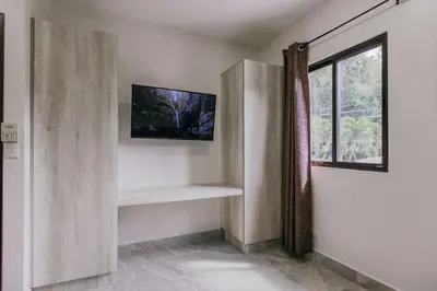 a room with a tv on a wall with a window at Casa Sol in Punta Leona