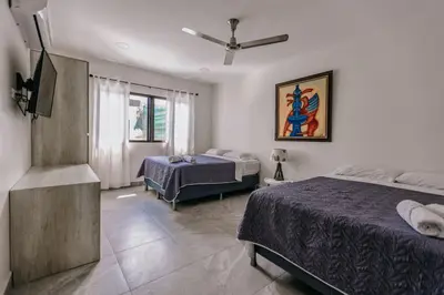 a bedroom with two beds and a tv in it at Casa Luna in Punta Leona