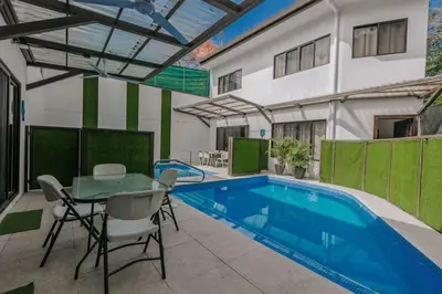 a patio with a pool and a table and chairs at Casa Luna in Punta Leona
