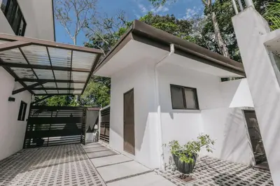 a white house with a glass roof and a patio at Casa Luna in Punta Leona