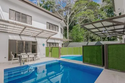a house with a swimming pool and a patio at Casa Luna in Punta Leona
