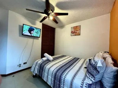 a bedroom with a bed and a ceiling fan at . 5 min Walking Beach Jaco Apartment in Jacó