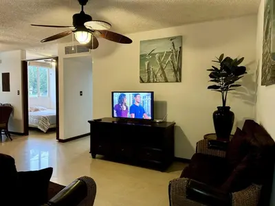 a living room with a flat screen tv on a dresser at . 5 min Walking Beach Jaco Apartment in Jacó