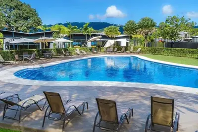 a pool with chairs and umbrellas at a resort at Casa Arenas in Herradura