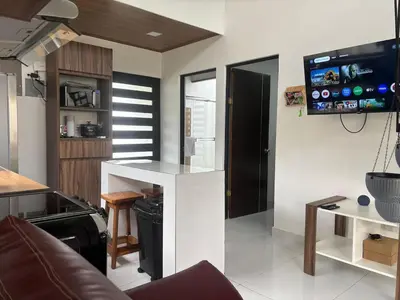 a living room with a white counter and a tv at Casa Arenas in Herradura
