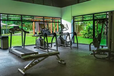 a gym with several tread machines in a room at Casa Arenas in Herradura