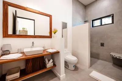 a bathroom with a sink and a toilet and a mirror at .Lujosa casa en Hacienda Pinilla in Tamarindo