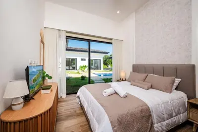 a bedroom with a bed and a television and a window at .Lujosa casa en Hacienda Pinilla in Tamarindo