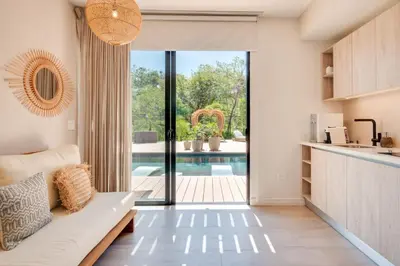 a living room with a couch and a sliding glass door at The Bungalows #4 - Boutique Hotel in Flamingo Beach - Top Level Studio in Playa Flamingo
