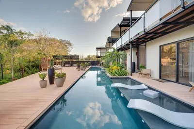 an outdoor swimming pool with a deck and a house at The Bungalows #5 - Boutique Hotel in Flamingo Beach - Ground Level Studio in Playa Flamingo