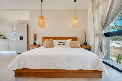 a bedroom with a white bed and a large window at The Bungalows #2 - Boutique Hotel in Flamingo Beach - Top Level Studio in Playa Flamingo