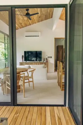 an open living room and dining room with sliding glass doors at CASA TUCAN , New House with Pool in Paradise, jungle view in Santa Teresa Beach