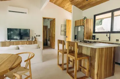 a kitchen and living room with a table and chairs at CASA TUCAN , New House with Pool in Paradise, jungle view in Santa Teresa Beach