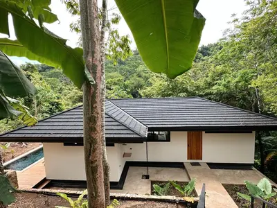 a house in the jungle with a black roof at CASA TUCAN , New House with Pool in Paradise, jungle view in Santa Teresa Beach