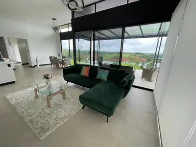 a living room with a green couch and a table at Colina Wilson in Santa Teresa