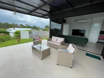 a patio with chairs and a television and a table at Colina Wilson in Santa Teresa