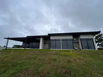 a building with a black roof on top of a field at Colina Wilson in Santa Teresa