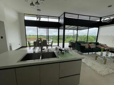 a kitchen with a sink and a living room at Colina Wilson in Santa Teresa