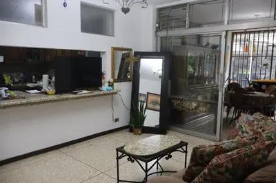 a living room with a couch and a tv and a table at Hospedaje Turismo Académico Costa Rica in San Pedro