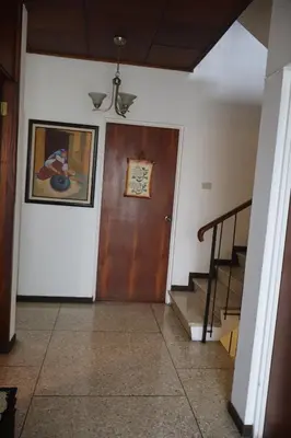 a hallway with a wooden door and a staircase at Hospedaje Turismo Académico Costa Rica in San Pedro