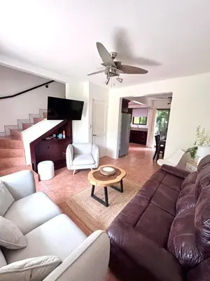 a living room with a couch and a table at Coco Daydreamin with a Rooftop Terrace in Coco
