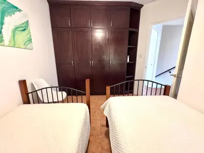 two beds in a room with a wooden door at Coco Daydreamin with a Rooftop Terrace in Coco
