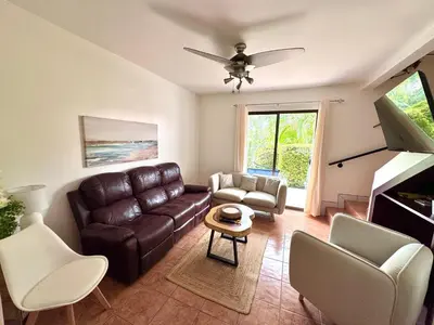 a living room with a leather couch and chairs at Coco Daydreamin with a Rooftop Terrace in Coco