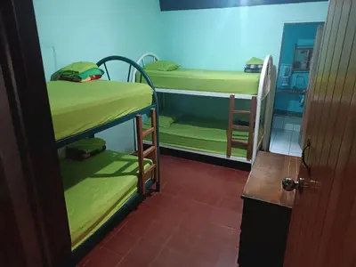 a room with two bunk beds and a door at Hostel Monteverde Backpackers in Monteverde Costa Rica