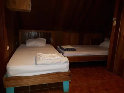 two twin beds in a small room withthritisthritisthritisthritisthritisthritisthritisthritis at Hostel Monteverde Backpackers in Monteverde Costa Rica