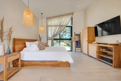 a bedroom with a white bed and a television at The Bungalows #1 - Boutique Hotel in Flamingo Beach - Ground Level Studio in Playa Flamingo
