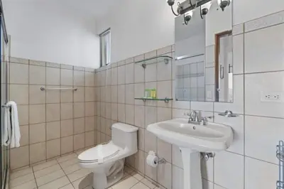 a bathroom with a toilet and a sink at Stunning Condo with Panoramic Beach, Ocean, and Mountain Views in Playa Flamingo in Playa Flamingo