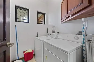 a white laundry room with a washer and dryer at Stunning Condo with Panoramic Beach, Ocean, and Mountain Views in Playa Flamingo in Playa Flamingo