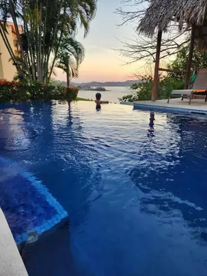 a boy in a swimming pool at a resort at Stunning Condo with Panoramic Beach, Ocean, and Mountain Views in Playa Flamingo in Playa Flamingo