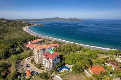 an aerial view of a resort next to the ocean at Stunning Condo with Panoramic Beach, Ocean, and Mountain Views in Playa Flamingo in Playa Flamingo