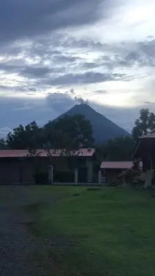 a mountain in the distance with a house and trees at Volcano Refuge House in Fortuna