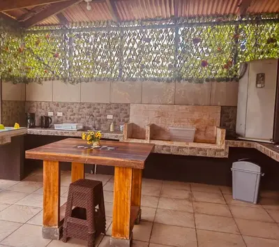 a kitchen with a wooden table and a bench at Volcano Refuge House in Fortuna