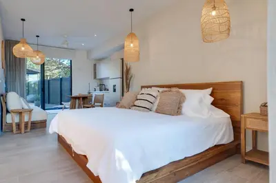 a bedroom with a large white bed and a living room at The Bungalows #7 - Boutique Hotel in Flamingo Beach - Ground Level Studio in Playa Flamingo