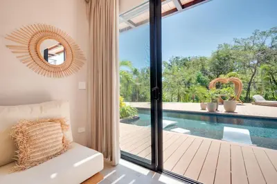 a living room with a view of a pool at The Bungalows #8 - Boutique Hotel in Flamingo Beach - Top Level Studio in Playa Flamingo