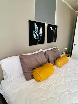 a white bed with three pillows on top of it at Apartamento Einoah in Puerto Limón