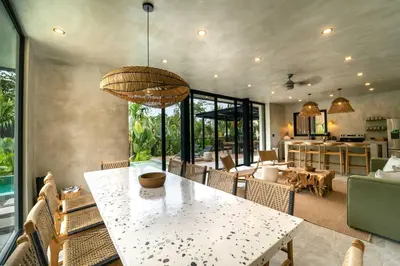 a dining room with a table and a kitchen at Manuel Antonio Tree House Villas - 4 Bedrooms in Quepos