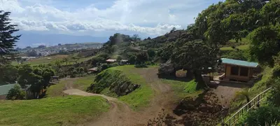 a small house on a hill with a dirt road at Hospedaje Jac Cabaña de Campo in Cartago