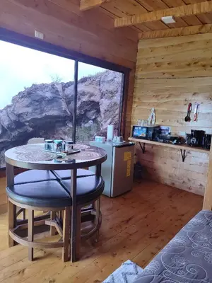 a kitchen with a table and chairs in a cabin at Hospedaje Jac Cabaña de Campo in Cartago