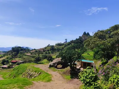 a dirt road on a hill with a house on it at Hospedaje Jac Cabaña de Campo in Cartago