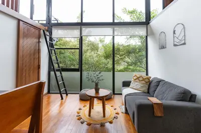 a living room with a couch and a table at NATURAVE HOME - Tiny house with mountain view in Monteverde Costa Rica