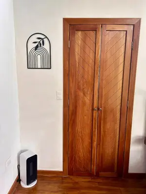 a wooden door in a room with a clock on the wall at NATURAVE HOME - Tiny house with mountain view in Monteverde Costa Rica