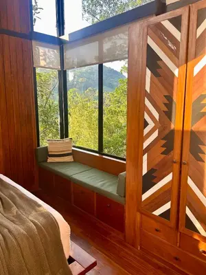 a window seat in a bedroom with a view at NATURAVE HOME - Tiny house with mountain view in Monteverde Costa Rica